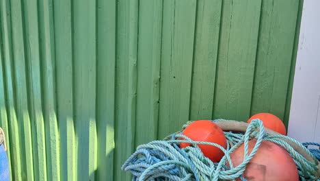 4K-60FPS-Blue-Plastic-Drums-Used-as-Well-Boxes-and-Fishing-Marker-Flags-Stored-Harbor-Next-to-Fishing-Sheds---Panning-Shot