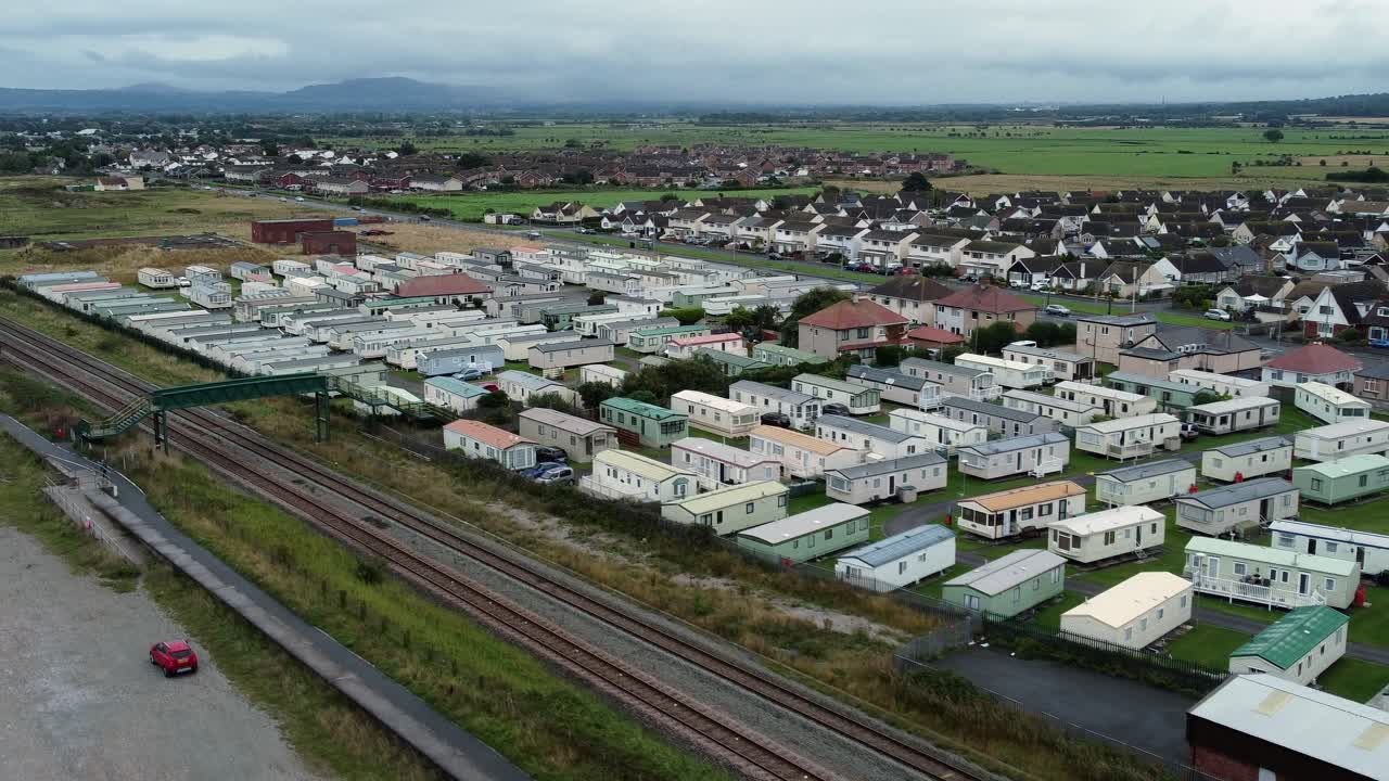remolque de caravana estática frente a la playa estancia casa de vacaciones camping resort vista aérea empujar lento a la izquierda
