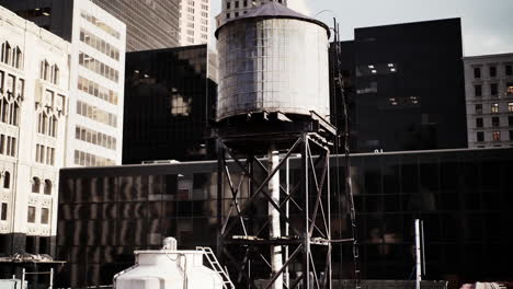 vieja torre de agua en el techo de una ciudad moderna