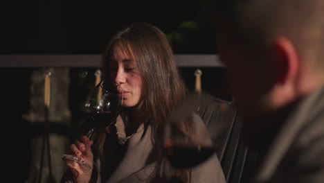 una pareja disfrutando del vino en un patio por la noche