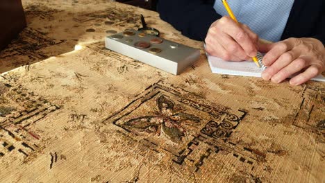 coin evaluator. the collector of coins. the man considers ancient coins.