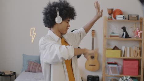 teenager dancing to music in bedroom