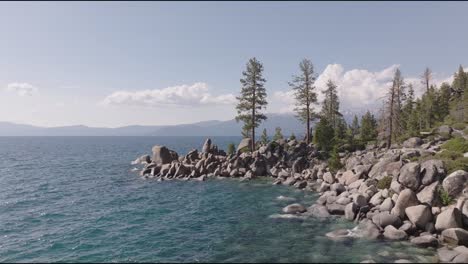 aerial shot of lake tahoe, overlooking part of the lake and rocky cliffs.