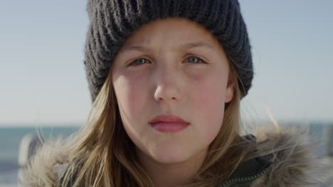 close up portrait cute little cacuasian girl looking serious wearing warm clothes beanie on seaside beach contemplative child slow motion