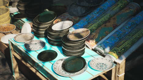 a table with ceramic plates for sale in a market