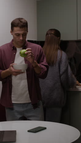 couple enjoying apples in the kitchen