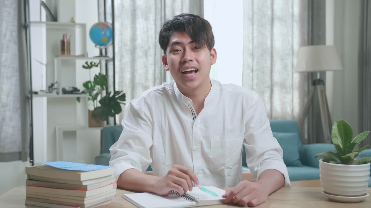 Asian Man Student Waving Hand And Talking At Home
