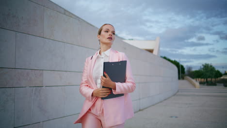 business manager going work holding documents at street. businesswoman walking