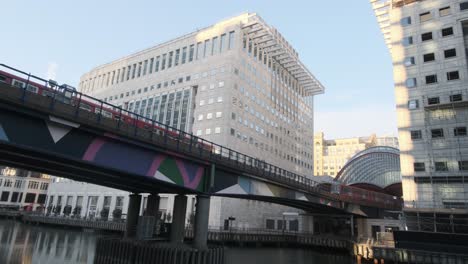 Two-London-DLR-trains-pass-each-other-on-bridge-over-middle-dock-Canary-Wharf-London