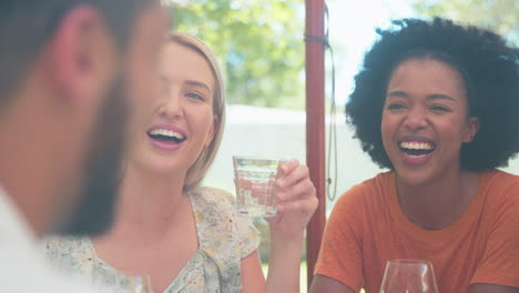 group of friends enjoying outdoor wine tasting on visit to vineyard