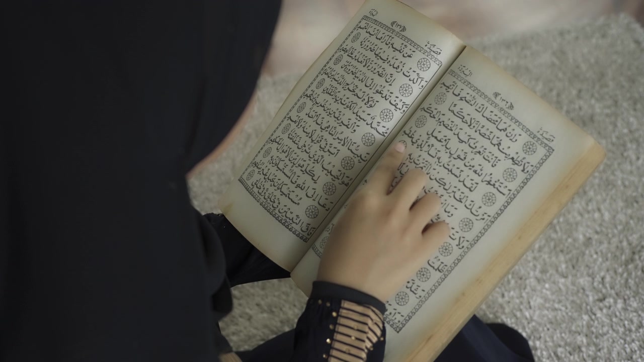 Una donna musulmana asiatica che recita la Salah o il passaggio della Sura al-Fatiha del Corano, in un singolo atto di sujud chiamato sajdah o prostrazione, a casa.