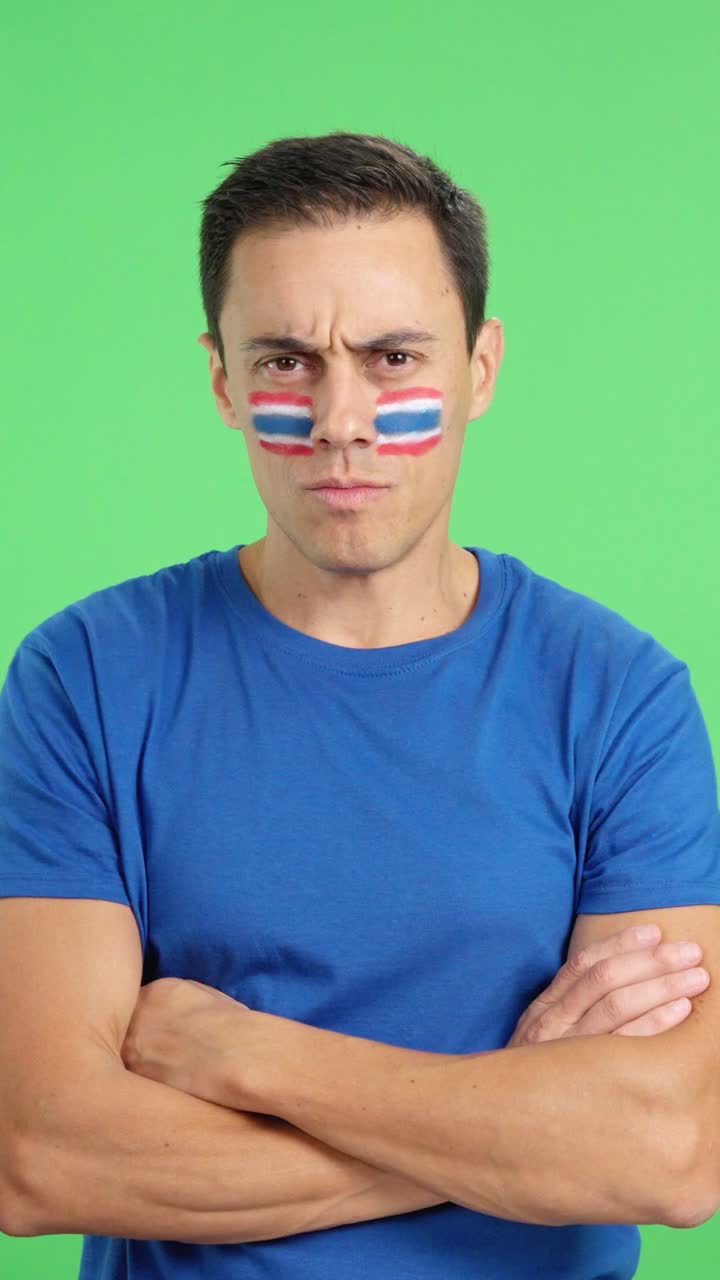 Dignified and serious man with thai flag painted on face