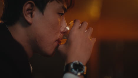 man drinking whiskey at a bar