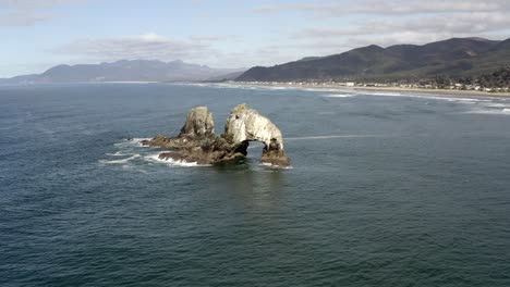 Rocas-Gemelas,-Playa-Rockaway,-órbita-Baja-Aérea,-Tarde-Clara