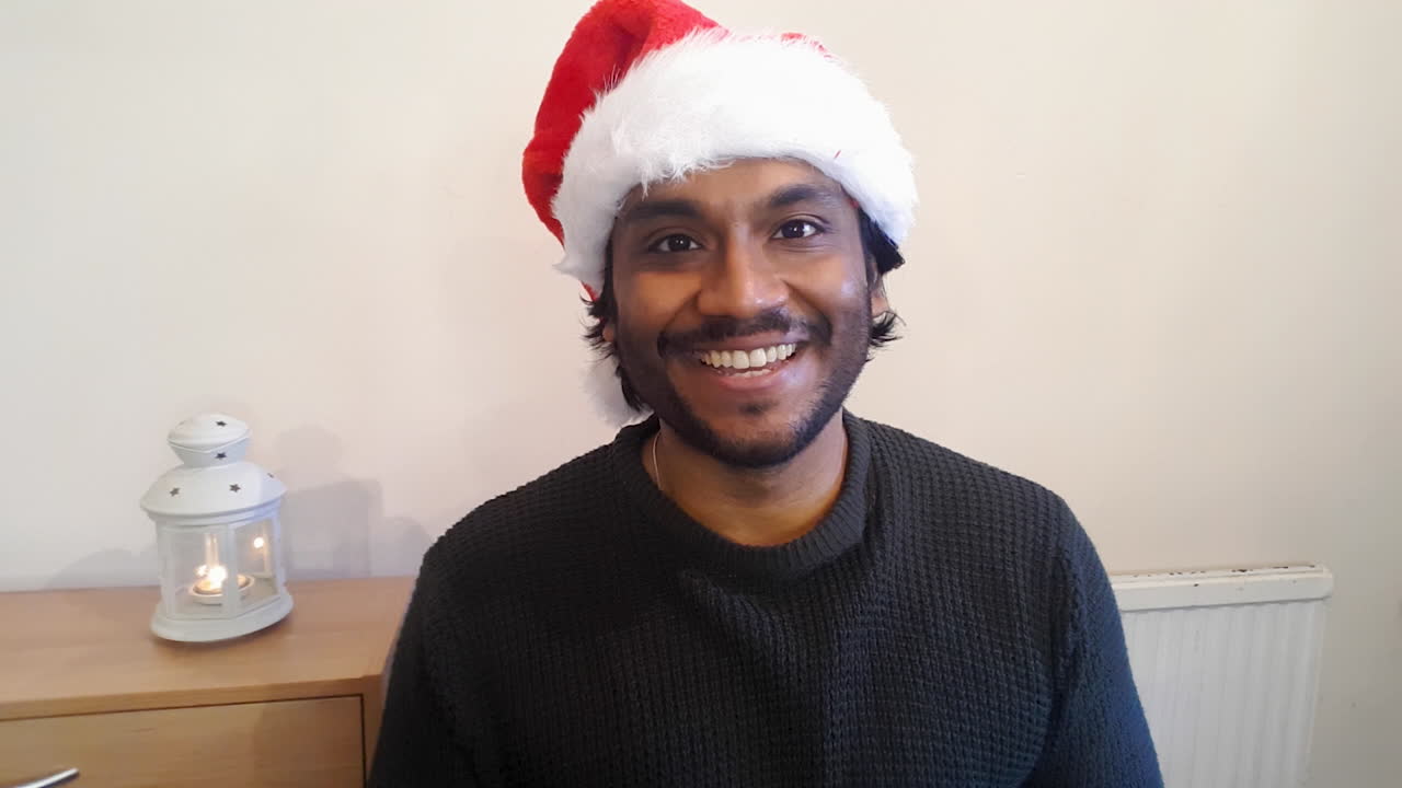 Young Man Joining Christmas Video Call Waving and Talking Directly to Camera