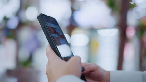 close-up of someone hand typing or chatting on a smartphone with a soft blurry background featuring bokeh lights, capturing a moment of digital communication in a modern, relaxed setting