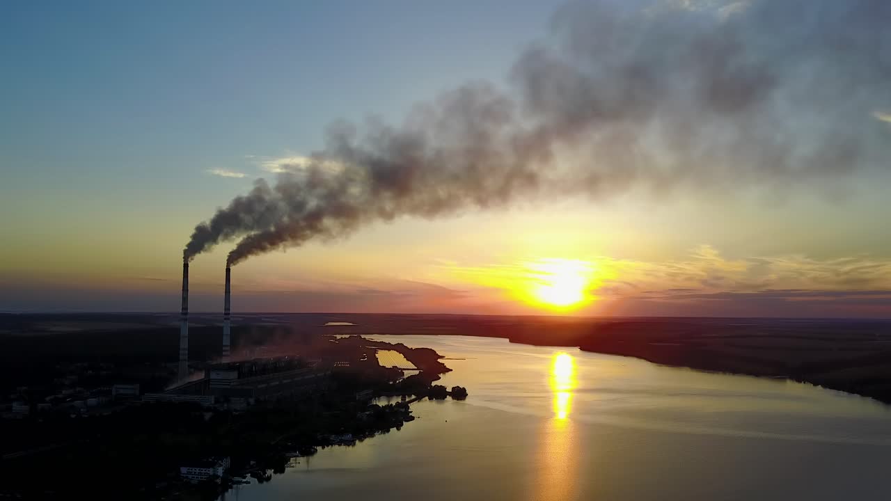 Pipe with smoke near people which spend time near river