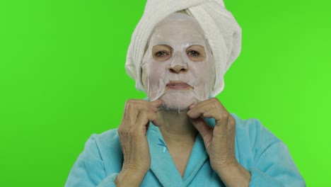 Elderly-grandmother-after-shower.-Old-woman-applying-cosmetic-fabric-face-mask