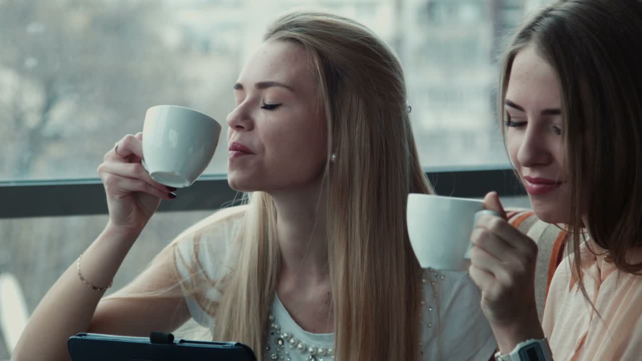 Two Girlfriends Drink Coffee