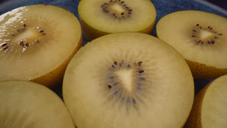 amazing close up rotating yellow kiwi fruits on a plate, juicy tropical exotic fruit, 4k macro shot