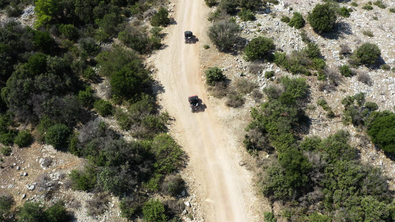 Aerial View of Dune Buggy Chase on Small Road Through the Rocky Wilderness