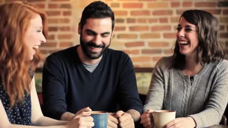 three friends enjoying laughter and warm drinks together in a cozy café setting, capturing the joyful moments of friendship and connection over coffee