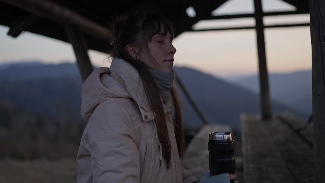Woman enjoying a hot drink in the mountains