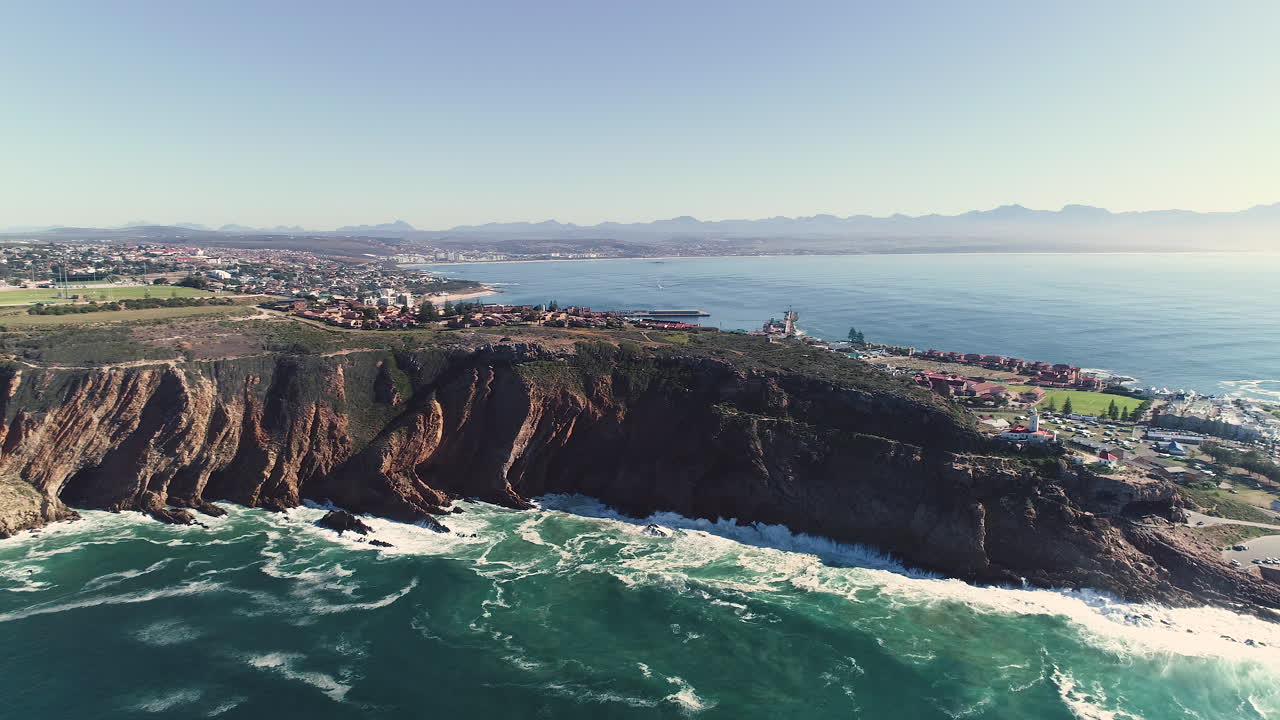 Aerial - Ascending drone flying backwards away from Cape St Blaize cliffs, showing the lighthouse and beautiful surrounding coastline