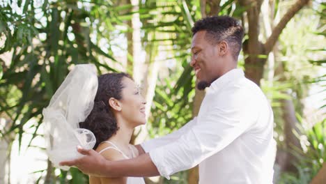 happy married african american couple unveiling veil and smiling