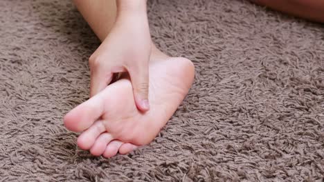 young woman massaging her foot on the after training or hard working day