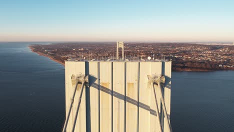 Aerial-view-revealing-traffic-on-the-Verrazzano-Narrows-bridge,-golden-hour-in-New-York,-USA---descending,-drone-shot