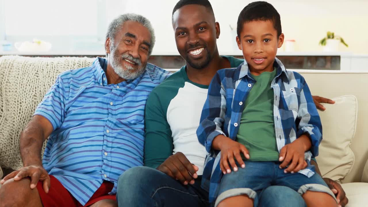 Smiling multi-generation family sitting together on sofa