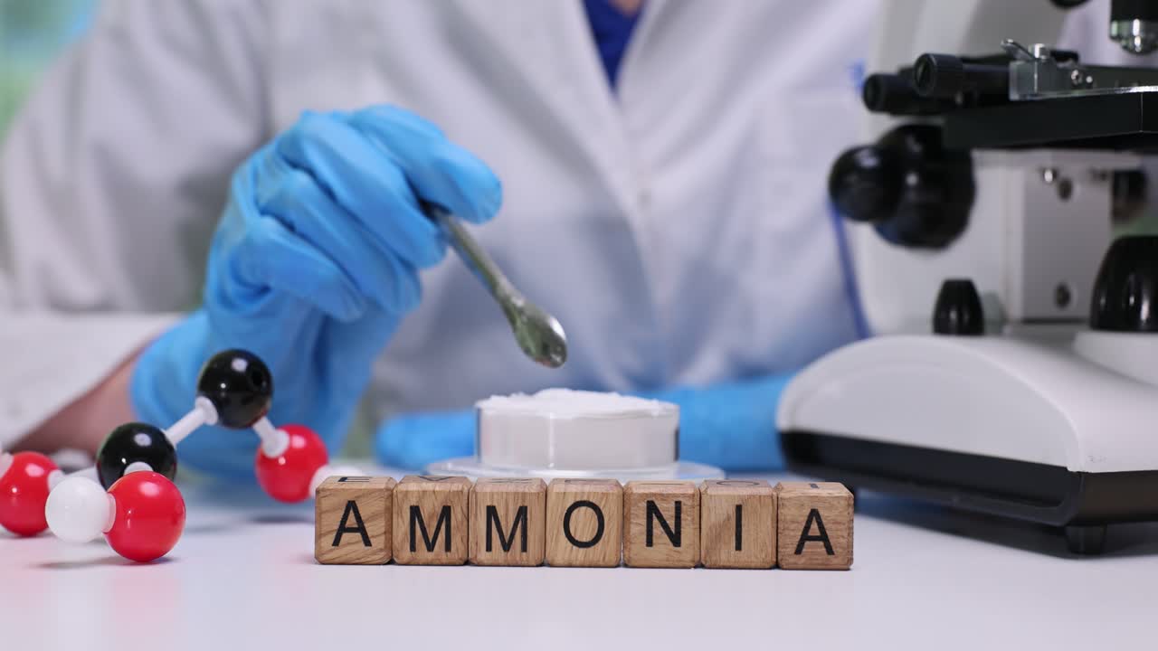 Un operatore di laboratorio mescola polvere bianca in un contenitore con un cucchiaio di metallo.