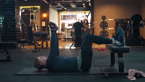 Caucasian Sportsman Doing Kettlebell Exercise Crunch Front Weight for the Abs in Modern Gym