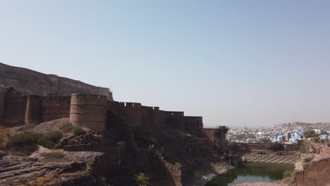 Toma-Panorámica-Amplia-Desde-La-Ciudad-Azul-De-Jodhpur-Hasta-El-Fuerte-De-Mehrangarh-En-Rajasthan,-India