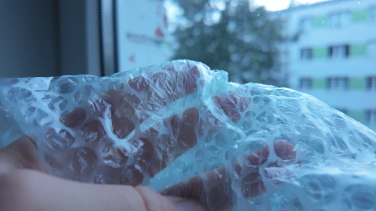 Scena di tensione di una mano che preme un foglio a bolle, simbolo di stress e ansia