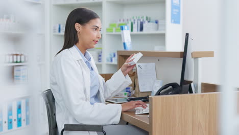 Young-pharmacist-working-on-computer-at-a-pharmacy