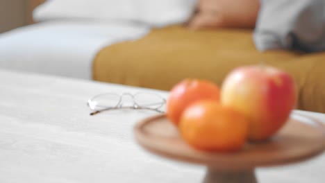 Woman's-Hand-Taking-Glass-Of-Water-On-The-Table-In-The-Living-Room