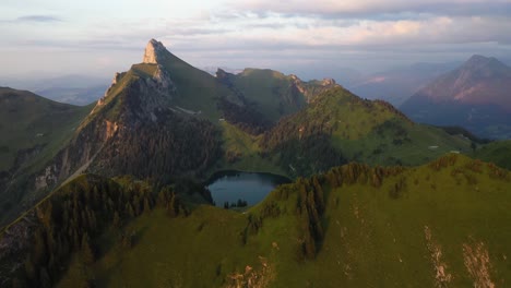 slow and steady drone shot of the top of stockhorn, switzerland with a small, pretty lake among sharp and dramatic edges of cliffs and peaks