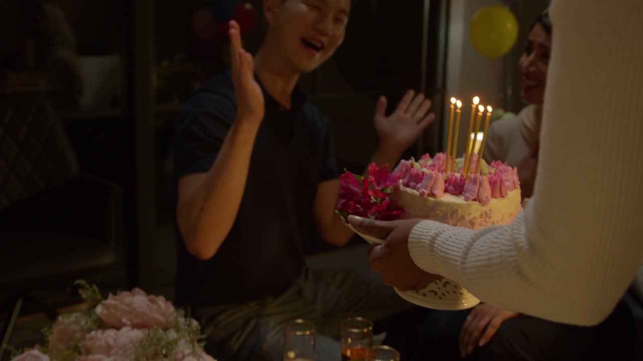 grupo multicultural celebrando el cumpleaños de amigos en casa con pastel y velas en la fiesta