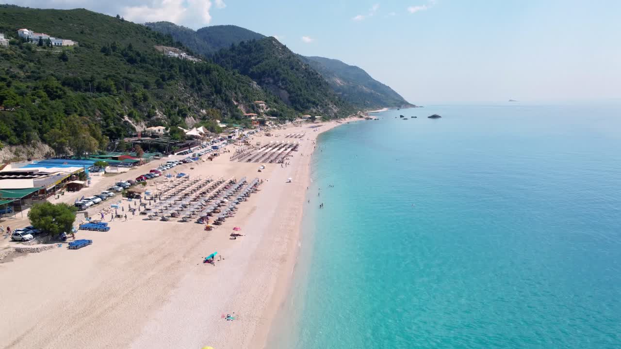 Sunshades and turquoise waves adorn Kathisma beach on Lefkada island in summer