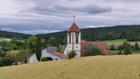 aerial shot approaching a church tower in a serene german hamlet