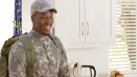 happy african american male soldier embracing with his wife at home, slow motion