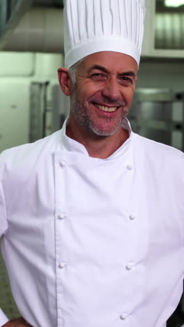 jefe de cocina sonriendo a la cámara con las manos en las caderas