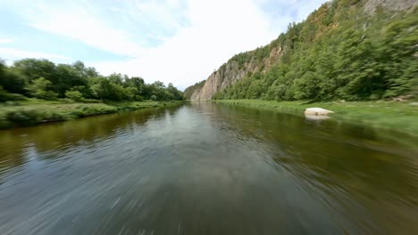 a warm summer day in beautiful terrain. the concept of outdoor activities and sports. a group of rowers moves along the river in inflatable boats.