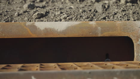 Close-Up-Panning-Shot-of-Sand-Covered-Storm-Drain-on-City-Sidewalk