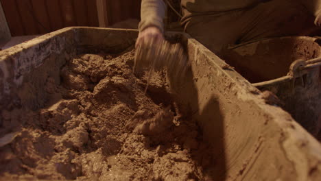 the clay mix being scooped out and into the plasterers bucket