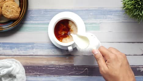 vertiendo leche en el té