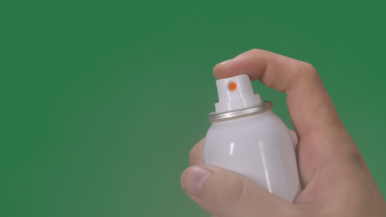 한 남자의 손은 카메라에 직접 에어로졸 소독제를 스프레이합니다. 코로나 바이러스 보호 및 예방. 팬데 코비드 2019을 예방합니다. 그린 스크린, 크로마 키, 느린 모션, 클로즈업.