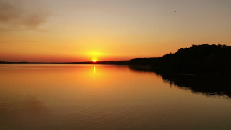 river at sunset. flight over the evening water. natural landscape of a lake at the setting sun. aerial view.